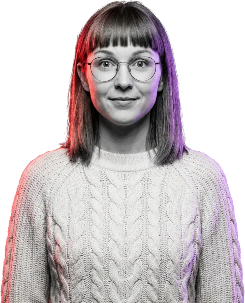Porträt einer Frau mit runder Brille und Stirnfransen im Strickpullover